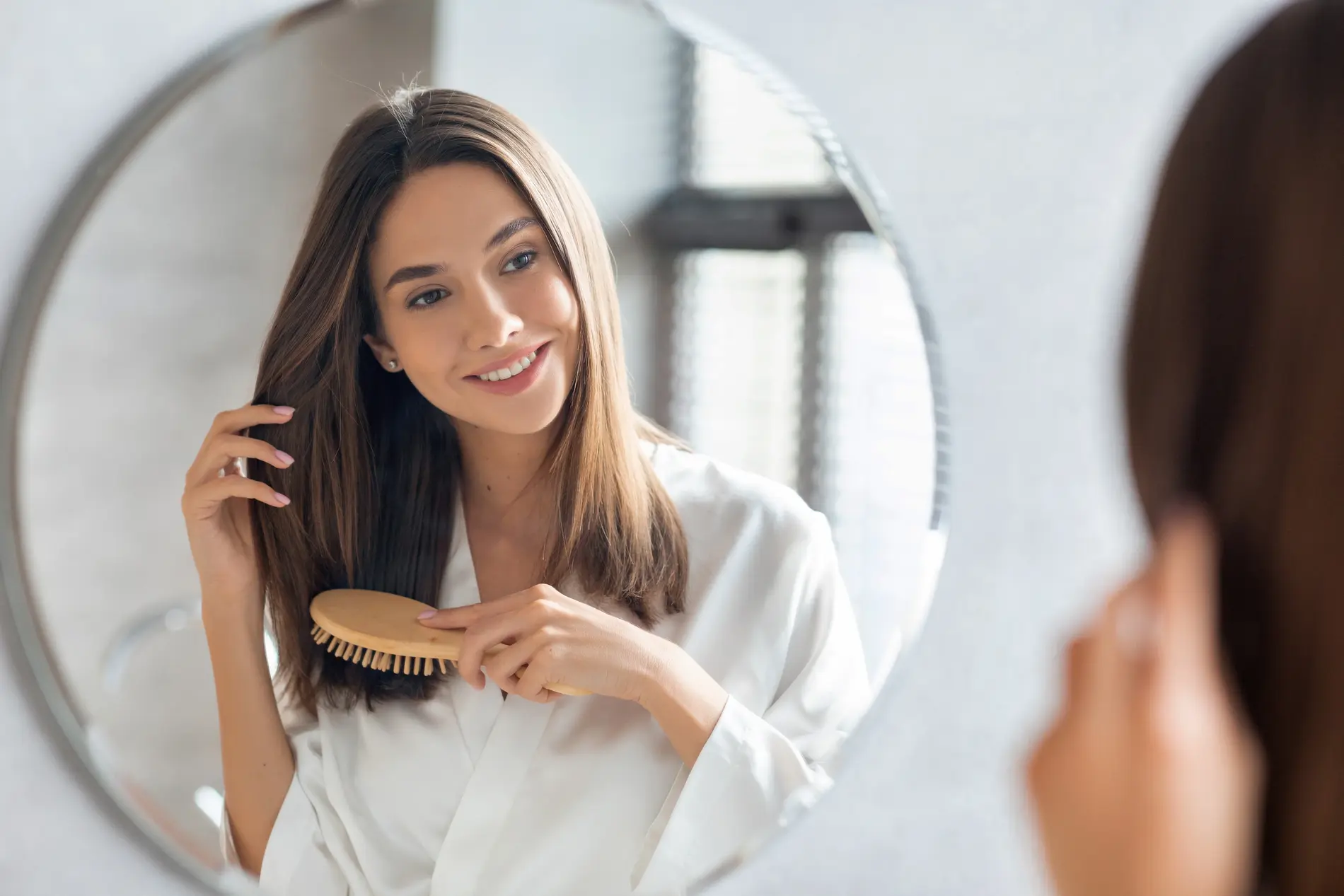 Haircare Concept. Attractive Young Lady Brushing Her Hair